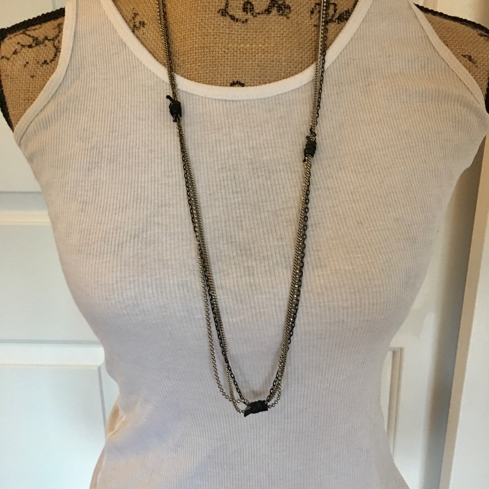 Long multi chain necklace with leather accent.